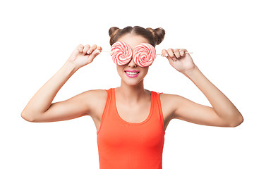 Image showing Portrait of woman with buns holding lollipops on eyes