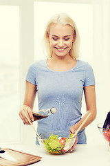 Image showing smiling woman cooking vegetable salad at home