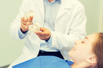 Image showing close up of dentist showing teeth maquette to girl