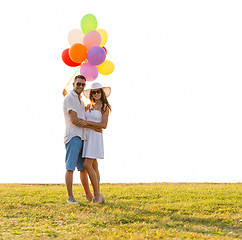 Image showing smiling couple with air balloons outdoors