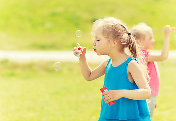 Image showing group of kids blowing soap bubbles outdoors