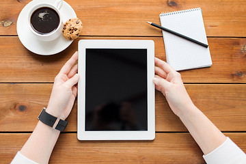 Image showing close up of woman with tablet pc on wooden table