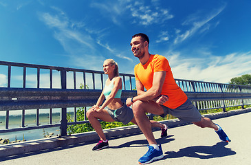 Image showing smiling couple stretching outdoors