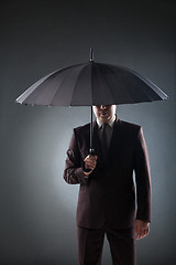 Image showing Businessman under umbrella