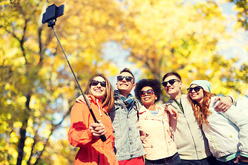 Image showing smiling friends taking selfie with smartphone