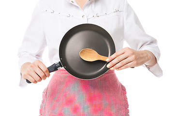 Image showing Close-up of woman holding frying pan and wooden spoon