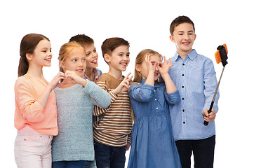 Image showing happy children with smartphone and selfie stick