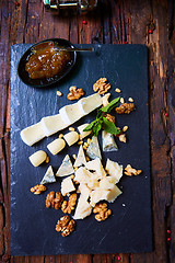 Image showing various cheeses on a wooden background