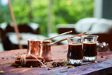 Image showing To pour arabic coffee in cups on wooden background.