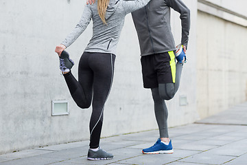 Image showing close up of couple stretching legs outdoors