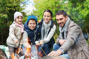 Image showing happy family roasting marshmallow over campfire