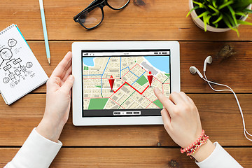 Image showing close up of woman with tablet pc on wooden table