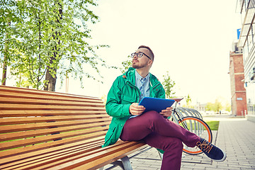 Image showing happy young hipster man with tablet pc and bike