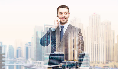 Image showing young smiling businessman calling on smartphone