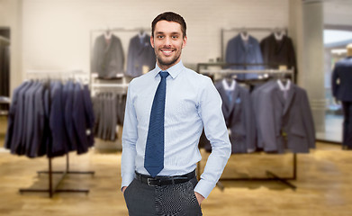 Image showing happy young businessman over clothing store