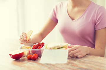 Image showing close up of woman with food in plastic container