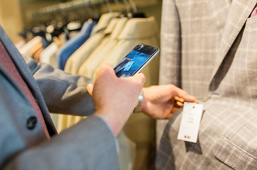 Image showing close up of man with smartphone at clothing store