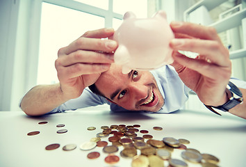 Image showing businessman with piggy bank and coins at office