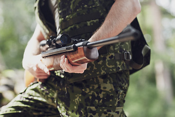 Image showing close up of soldier or hunter with gun in forest