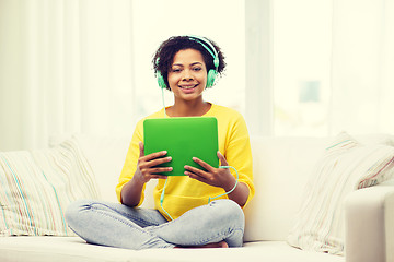 Image showing happy african woman with tablet pc and headphones