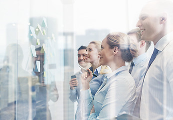 Image showing smiling business people with marker and stickers