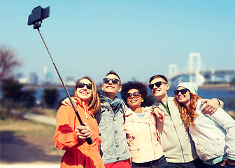 Image showing smiling friends taking selfie with smartphone