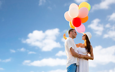 Image showing smiling couple with air balloons outdoors