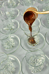 Image showing Pouring turkish coffee into traditional embossed cup.