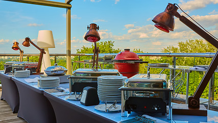 Image showing Table with dishware and shiny marmites waiting for guests.