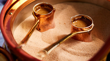 Image showing Preparation of Turkish coffee in the cezve in the sand at cafe bar