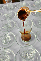 Image showing Pouring turkish coffee into traditional embossed cup.