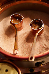 Image showing Preparation of Turkish coffee in the cezve in the sand at cafe bar