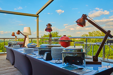 Image showing Table with dishware and shiny marmites waiting for guests.