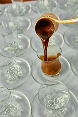 Image showing Pouring turkish coffee into traditional embossed cup.