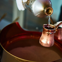 Image showing Preparation of Turkish coffee in the cezve in the sand at cafe bar