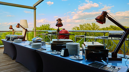 Image showing Table with dishware and shiny marmites waiting for guests.