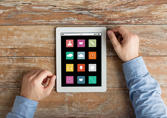 Image showing close up of male hands to tablet pc on table