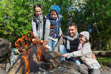 Image showing happy family roasting marshmallow over campfire