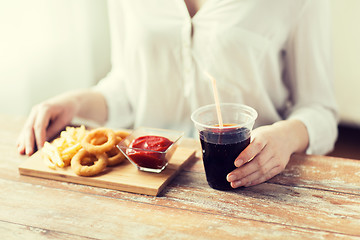 Image showing close up of woman with snacks and cola