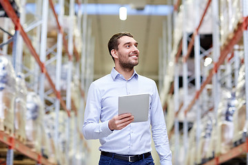 Image showing happy businessman with tablet pc at warehouse