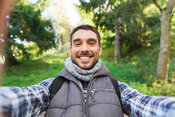 Image showing happy man with backpack taking selfie and hiking