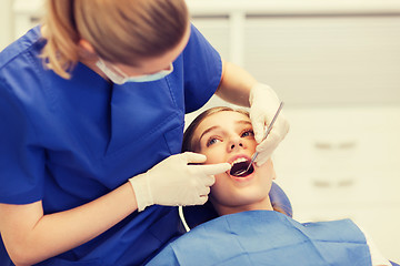 Image showing female dentist checking patient girl teeth