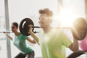 Image showing group of people exercising with barbell in gym