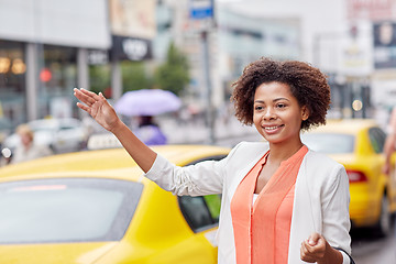 Image showing happy african woman catching taxi