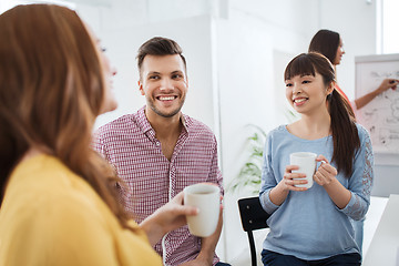 Image showing happy creative team drinking coffee at office