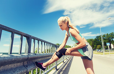 Image showing young woman with injured knee or leg outdoors