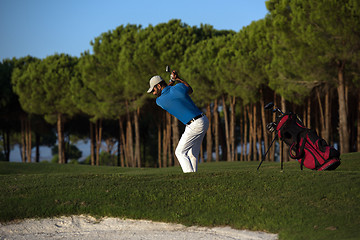 Image showing golfer hitting a sand bunker shot on sunset