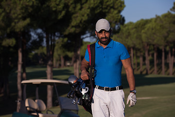 Image showing golfer  walking and carrying golf  bag