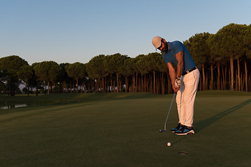 Image showing golfer  hitting shot at golf course