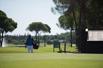 Image showing golf player walking and carrying bag